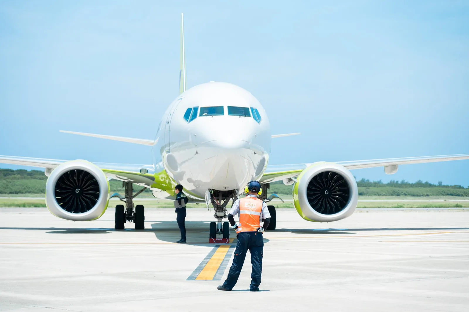 航空機の前に立つランプハンドリングスタッフ