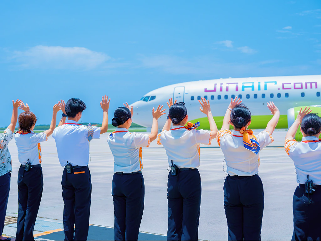 航空機を見送る空港スタッフ